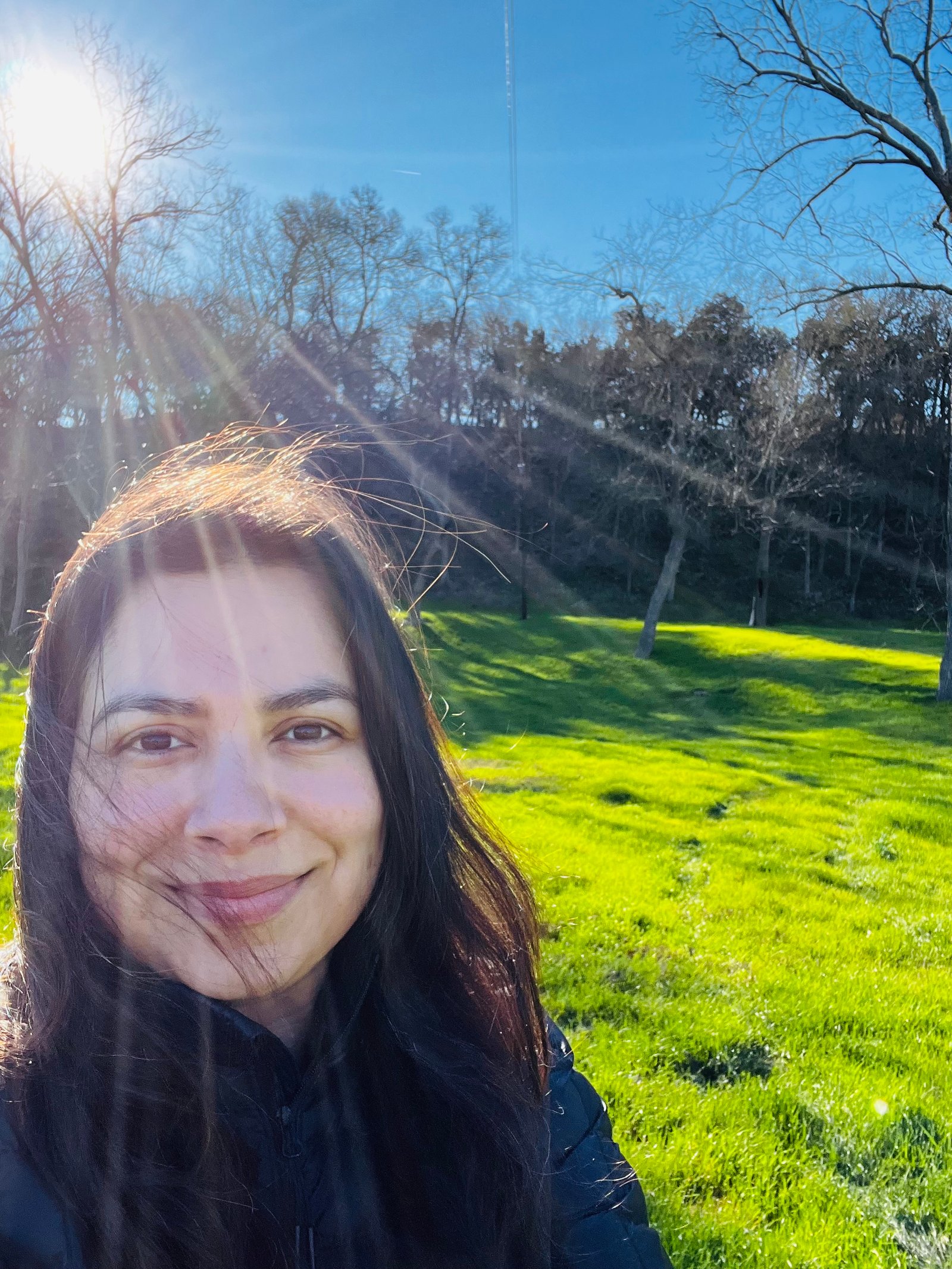 Irma smiling in a sunlit green field