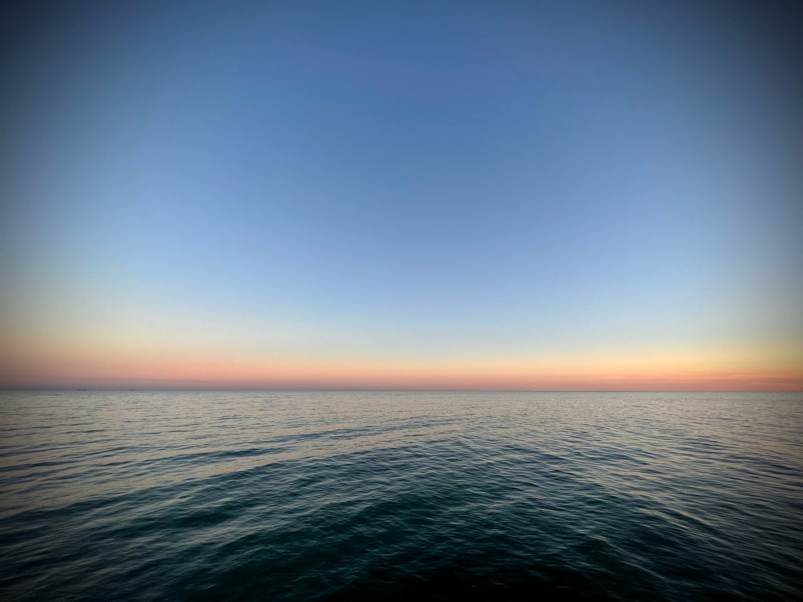 Quiet ocean water at dusk under a soft sky