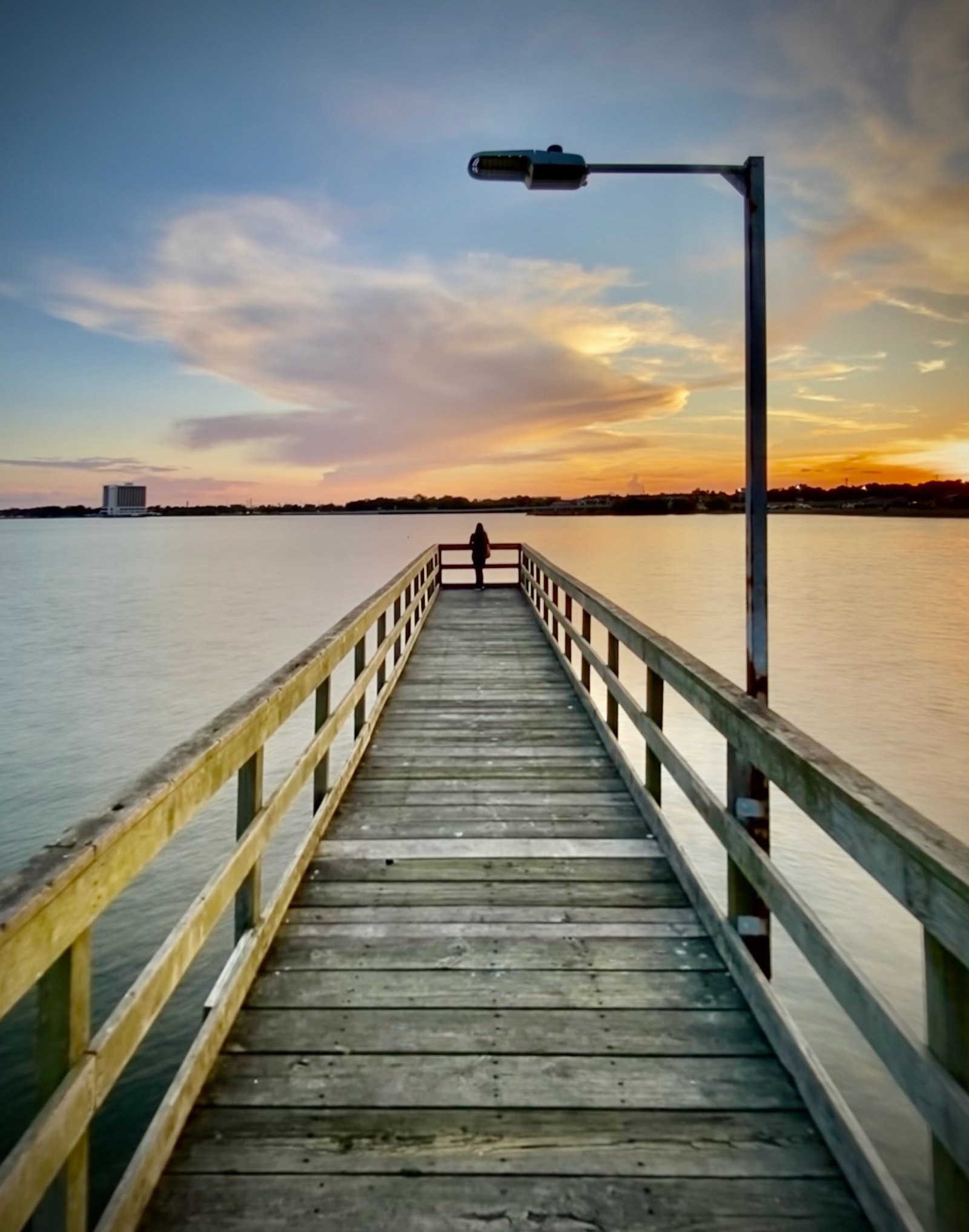 Standing at the end of the pier at sunset