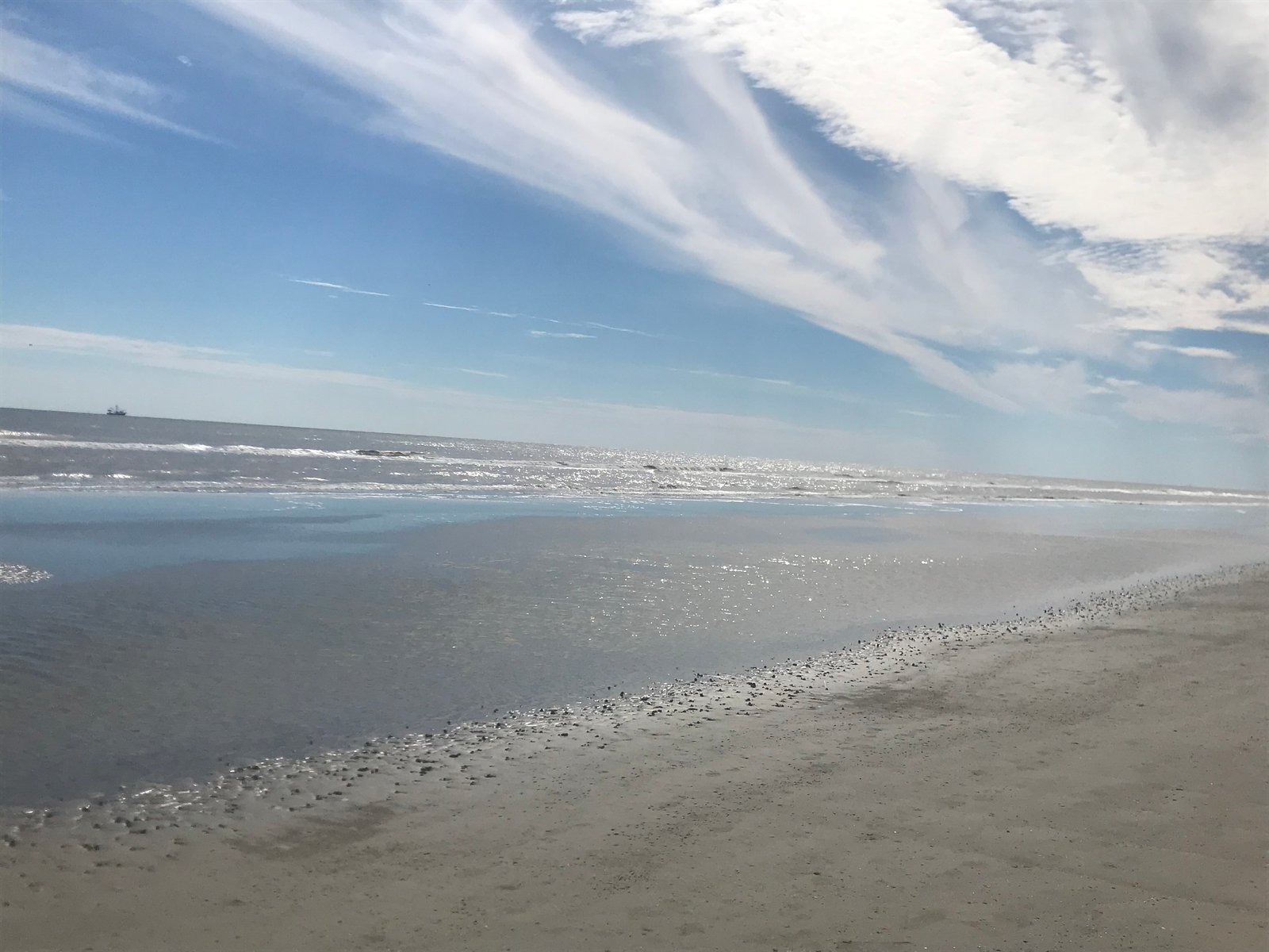 Sparkling shoreline and tide pool under a wide sky